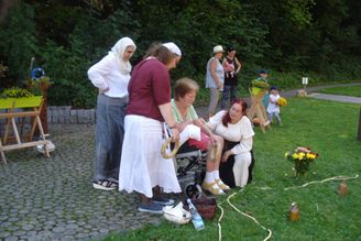 Frauen helfen einer älteren Frau im Rollstuhl im Park