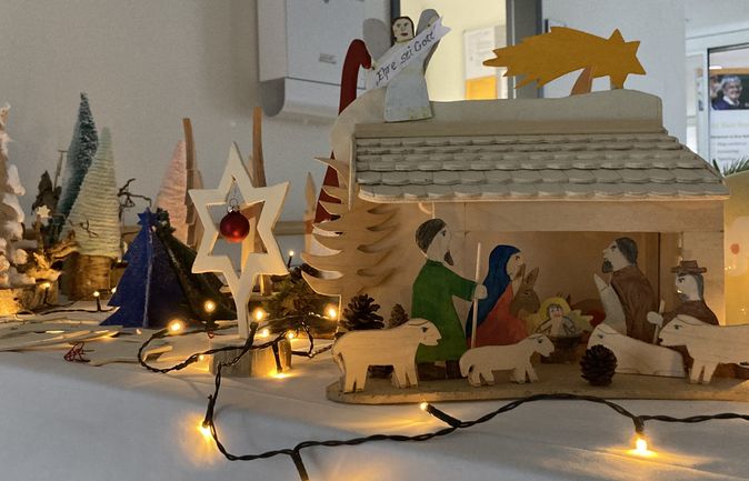 Adventstisch mit selbstgebastelter Holzkrippe und Lichterketten