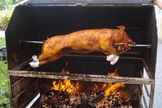 Ganzes Schwein am Spieß über offenem Feuer