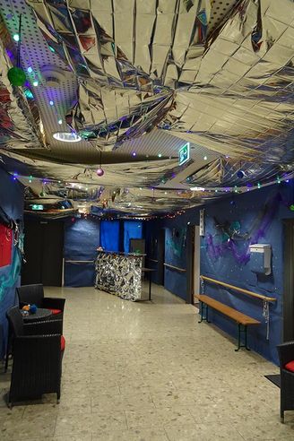 Flur mit metallischer Deckenfolie Lichterketten und blauen Wanddekorationen