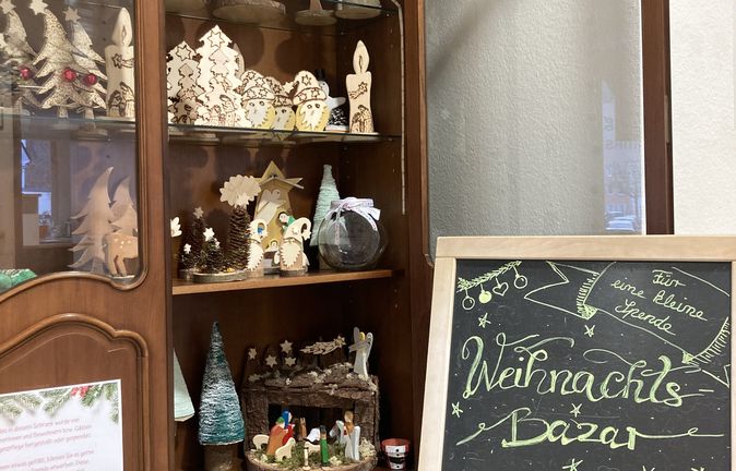 Vitrine mit handgefertigten Holz-Weihnachtsfiguren und Weihnachtsbazar-Kreidetafel