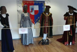 Schaufensterpuppen in historischen Kostümen hinter Absperrung mit Schildern Bitte nicht berühren Danke