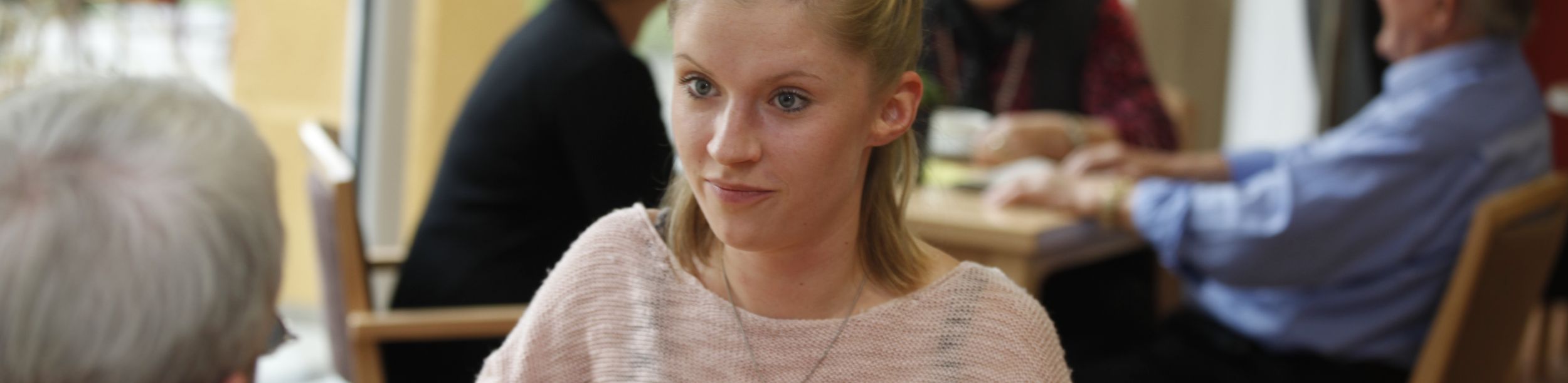 Junge Frau schält Apfel mit Schäler am Tisch