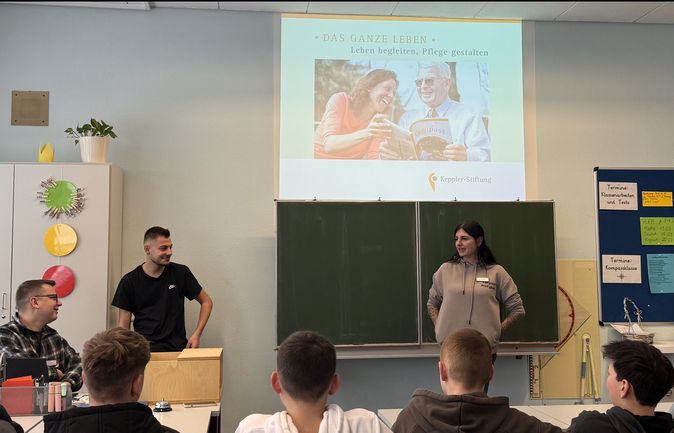 Zwei Ausbildungsbotschafter präsentieren Pflegeprojekt vor Klasse 8