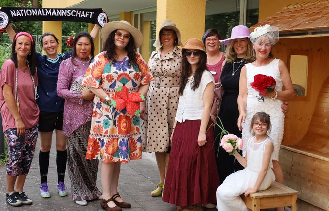Gruppe Frauen und Mädchen beim Erdbeerfest mit Erdbeerdeko und Blumen